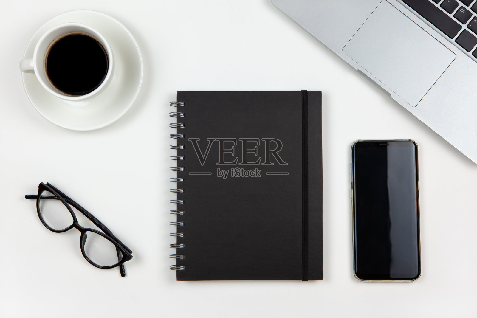 现代的工作空间,俯视图。笔记本电脑,咖啡,记事本,智能手机,白色背景上的眼镜,拷贝空间,平铺。桌面的自由职业者。利用科技概念,在家工作照片摄影图片