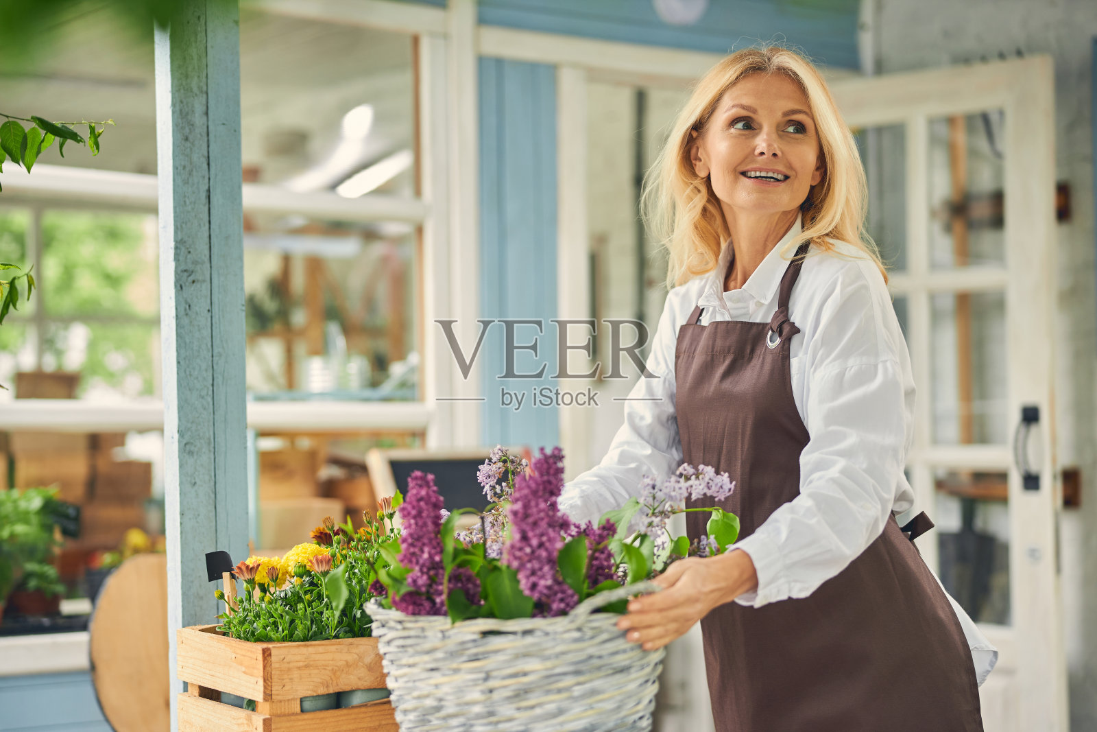 快乐的女人花店拿着柳条篮子照片摄影图片