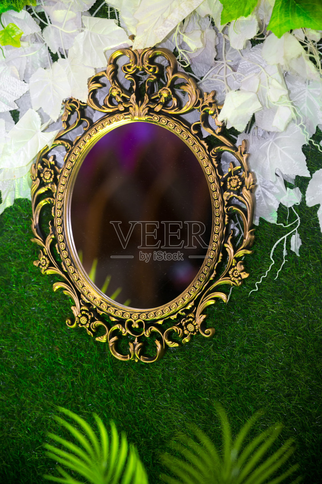 绿色人造草为主的婚礼舞台,手工制作的椭圆形梳妆台墙镜装饰背景。塑料人造花。婚礼装饰。照片摄影图片