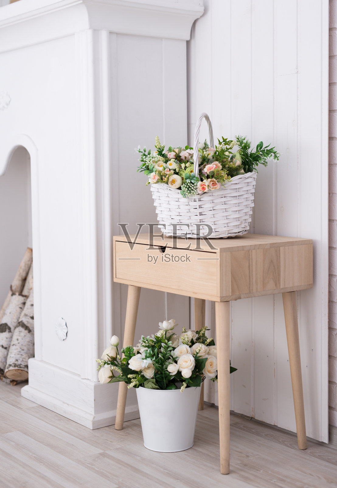 绿色植物在一个装饰的木花瓶在一个白色的房间的背景与一个书架。装饰室内的概念。照片摄影图片