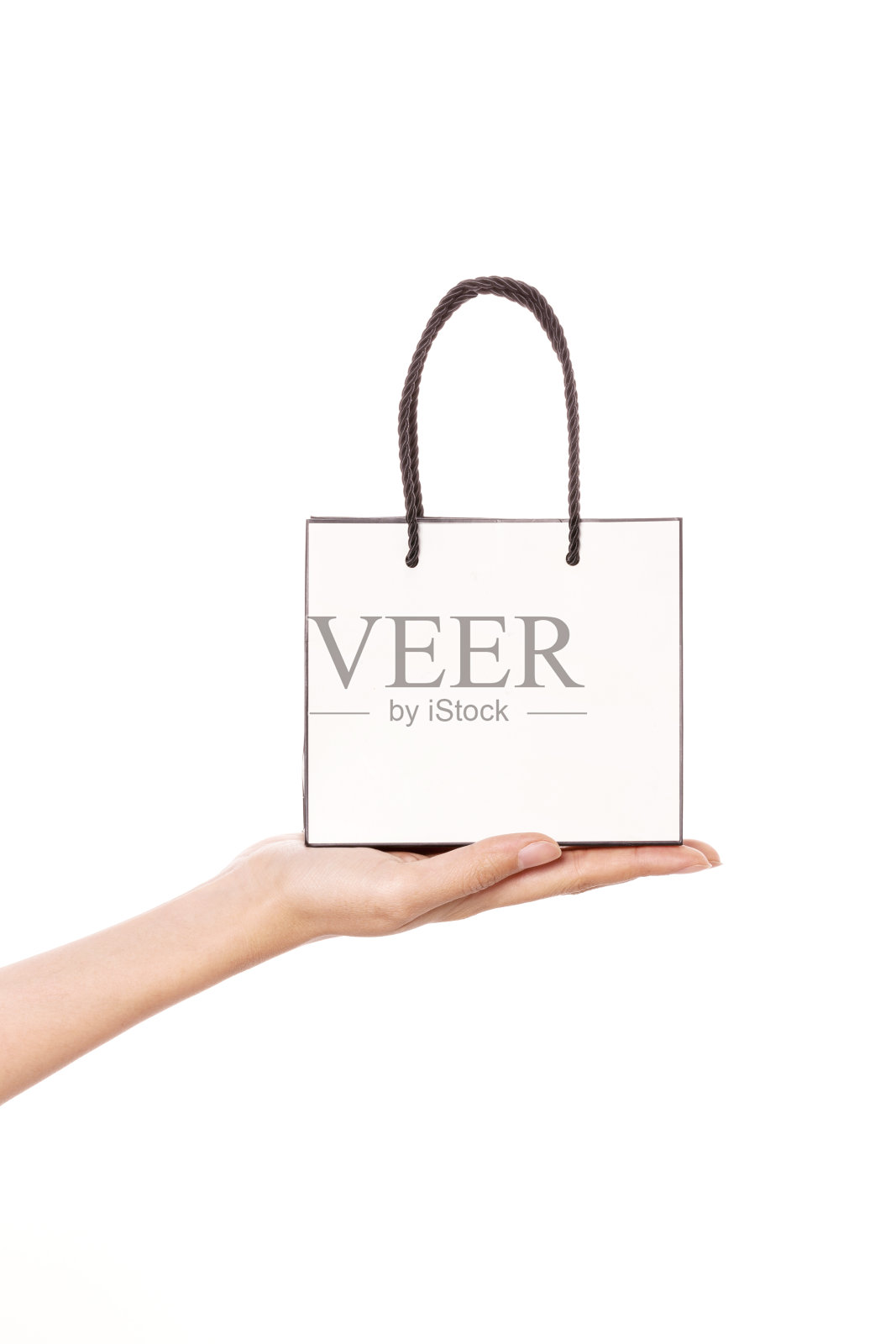 女人手里拿着一个购物袋孤立在白色。照片摄影图片