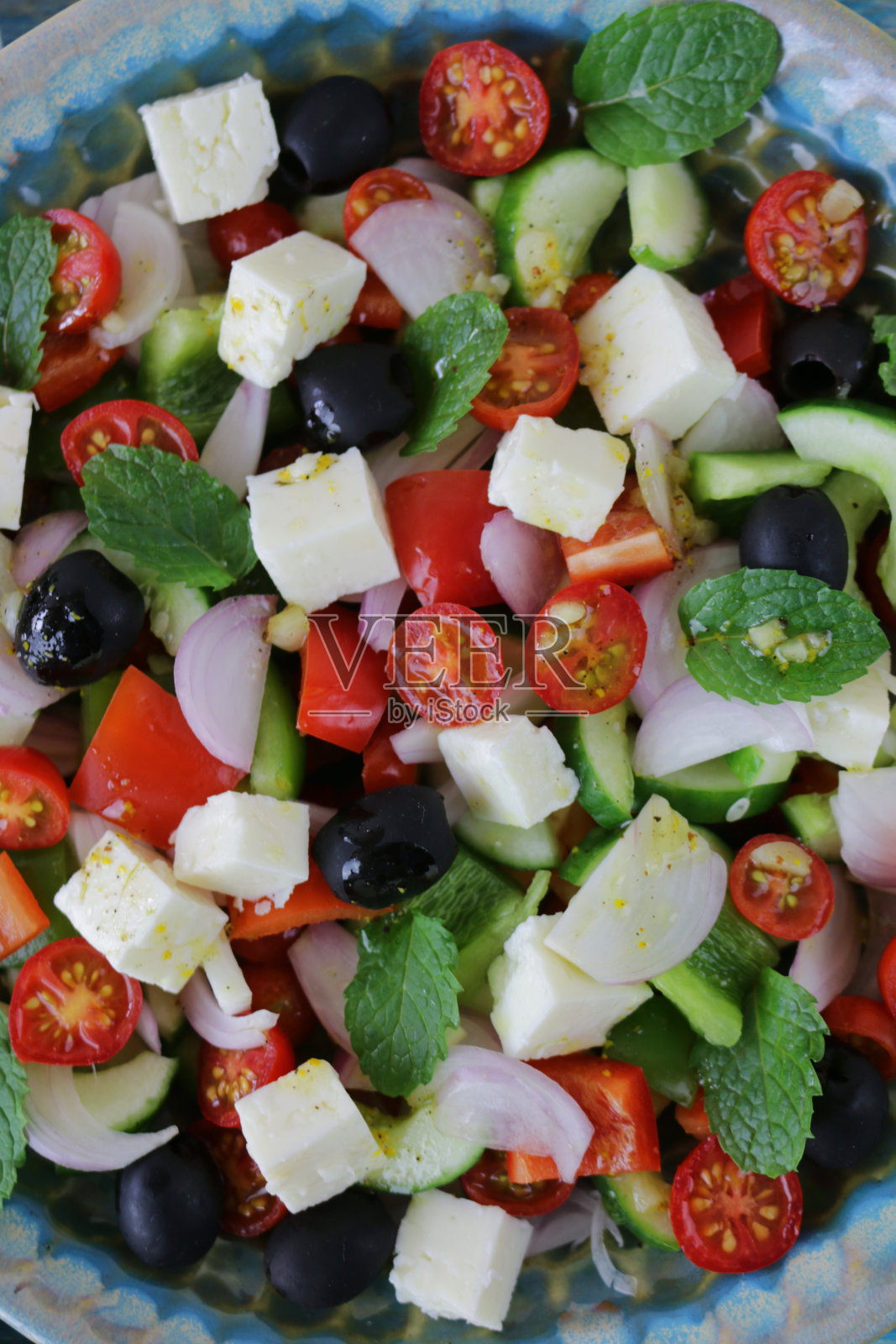 特写图像希腊(horiatiki)沙拉在图案碗,蔬菜包括,西红柿,黄瓜,洋葱,羊乳酪,薄荷叶和黑橄榄,俯瞰照片摄影图片