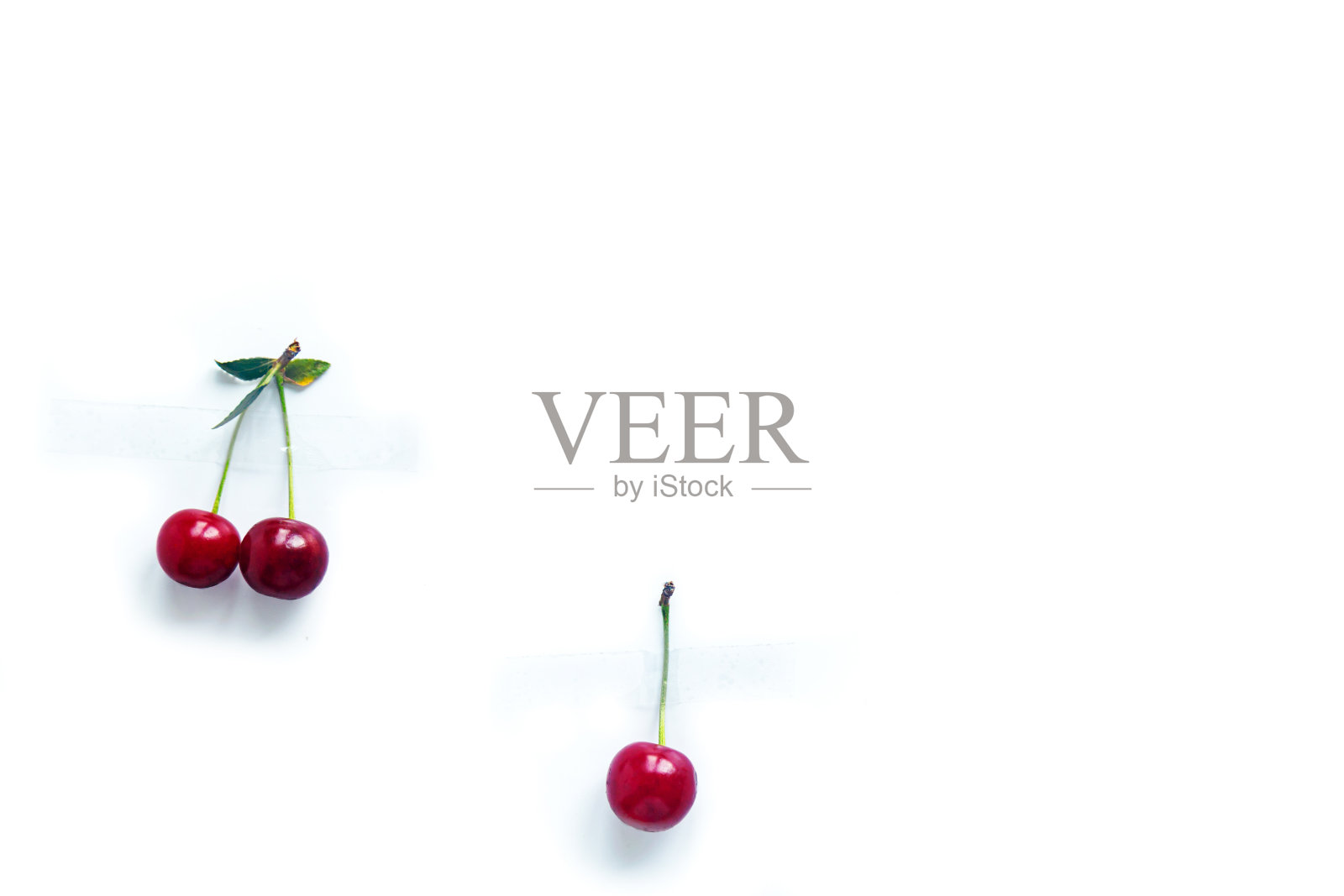 樱桃浆果和插枝用胶带粘在白色背景上照片摄影图片