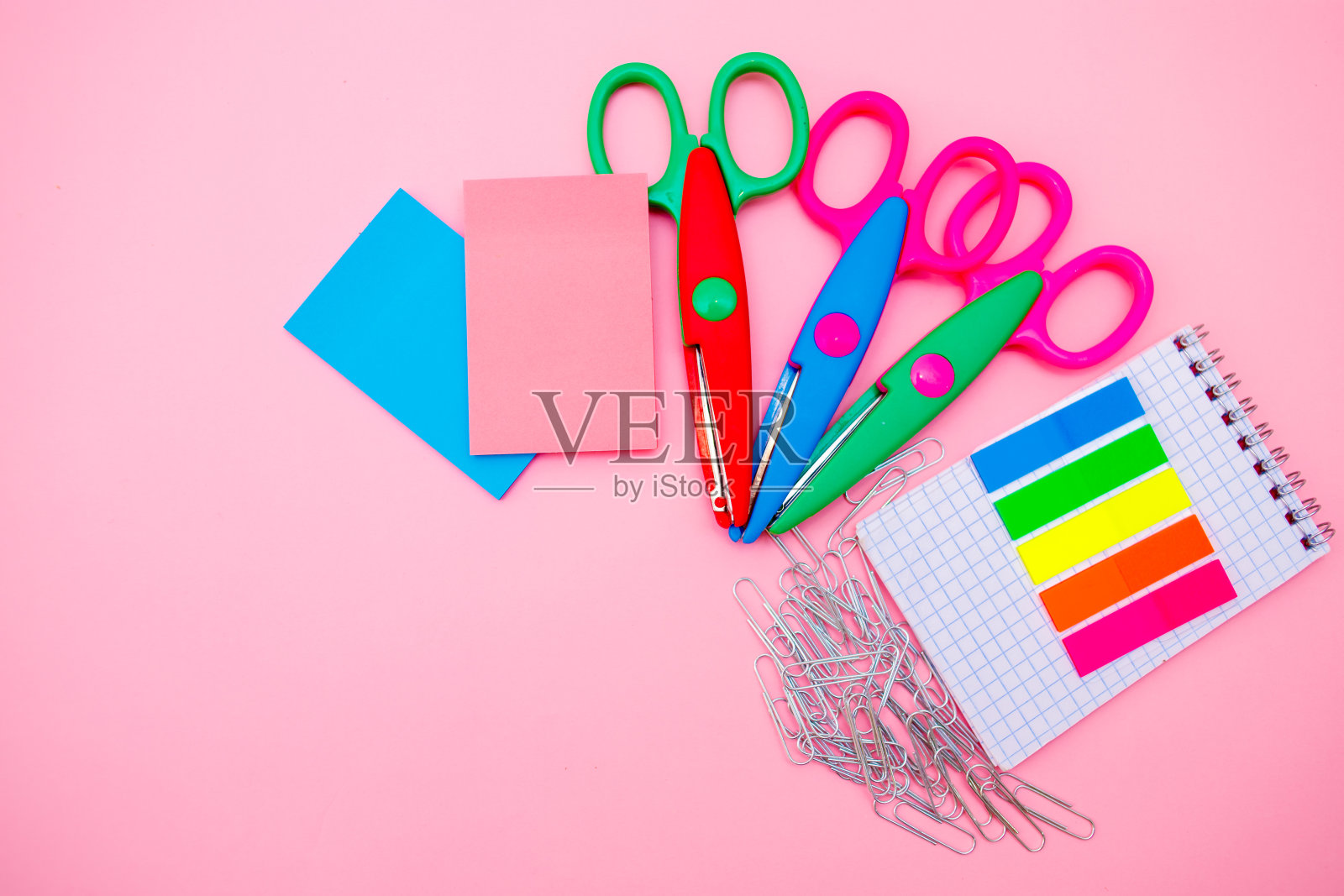 粉红色背景上的新学校用品。从上往下看照片摄影图片