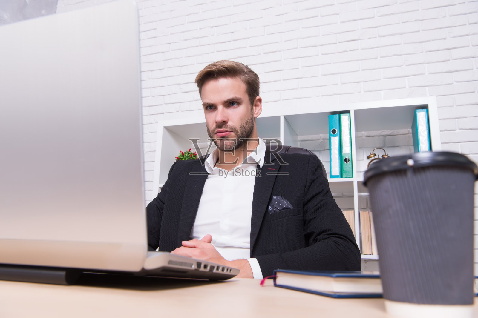 繁忙的日程。忙碌的商人在办公室用笔记本电脑工作。繁忙的工作日。运行的业务。商务沟通。现代生活。新技术。他正忙于一些重要的工作照片摄影图片