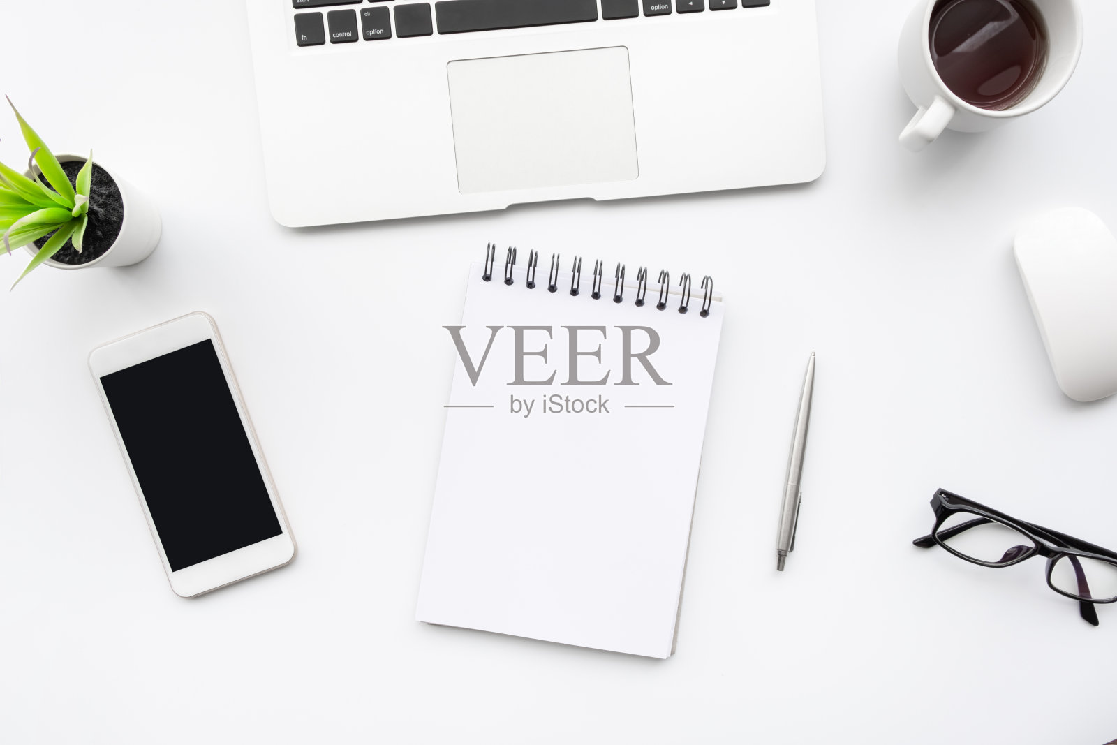 白色办公桌桌子白色智能手机与空白屏幕,笔记本电脑,笔记本电脑和用品。俯视图,平放。照片摄影图片