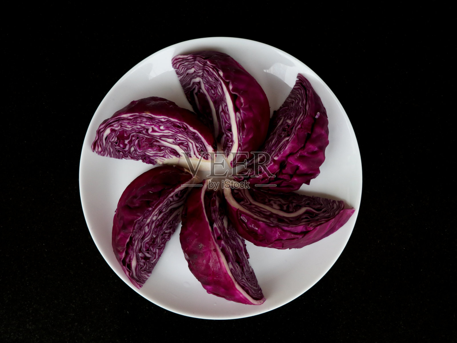 鲜嫩有机切成紫罗兰色的卷心菜,放在白色盘子里作质地、背景照片摄影图片