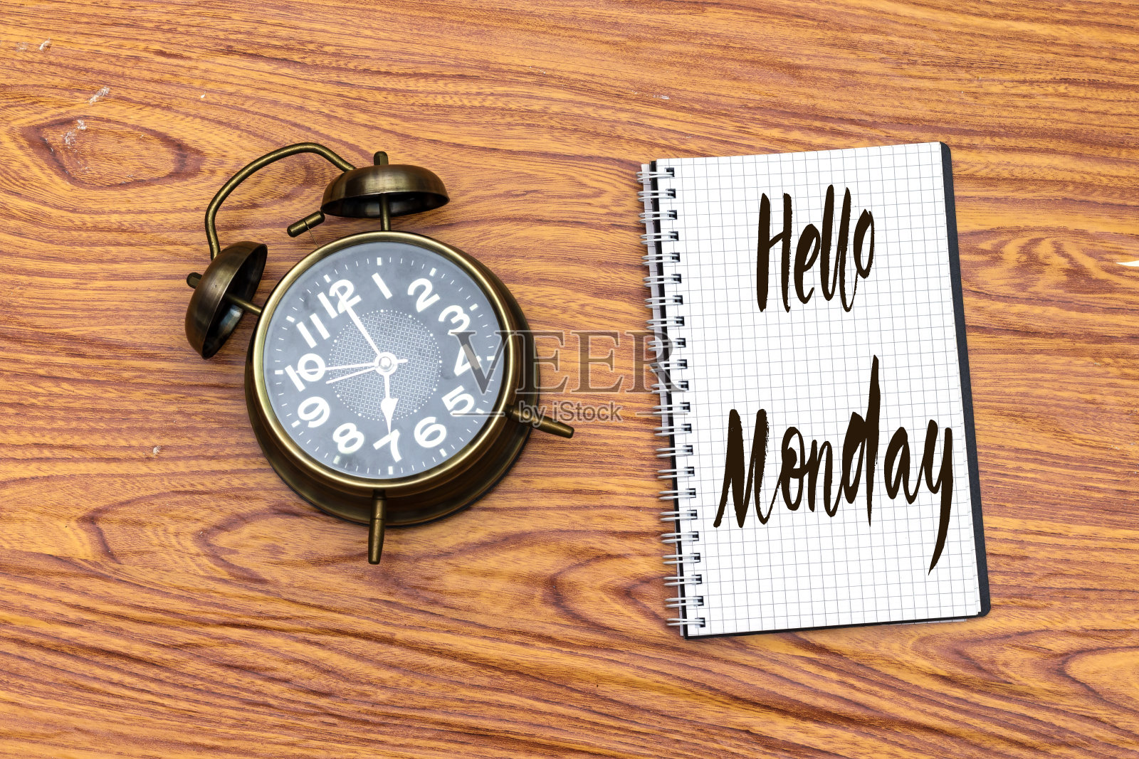 在笔记本上写你好星期一,闹钟显示7点照片摄影图片