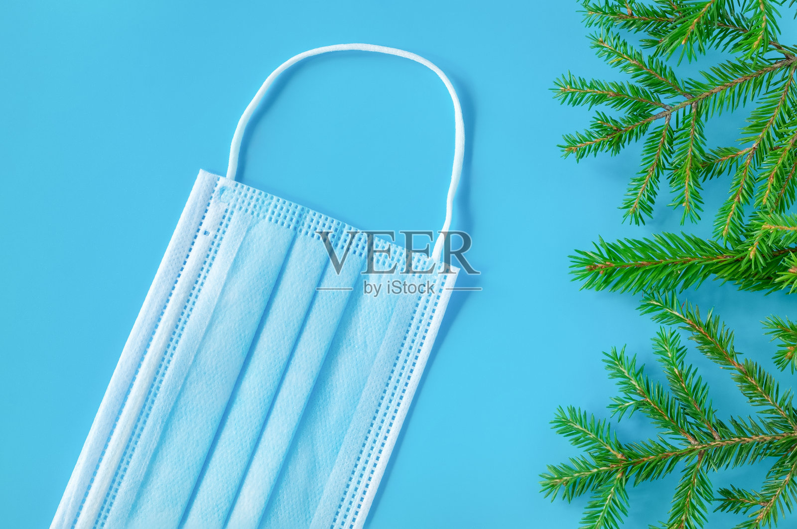 圣诞新年的背景有一棵圣诞树和一个医用面具。照片摄影图片