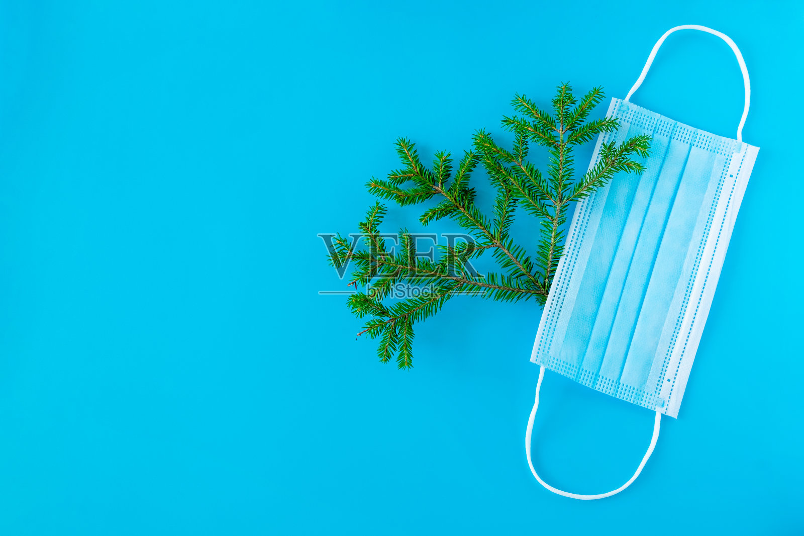 圣诞新年的背景有一棵圣诞树和一个医用面具。照片摄影图片