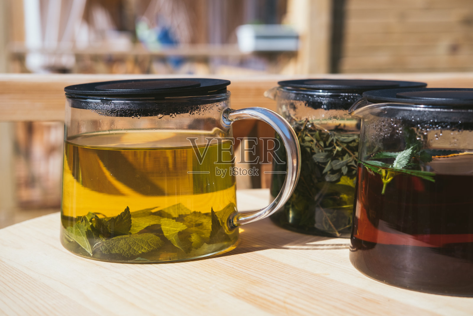 天然药草茶,木桌玻璃壶,山景为背景照片摄影图片