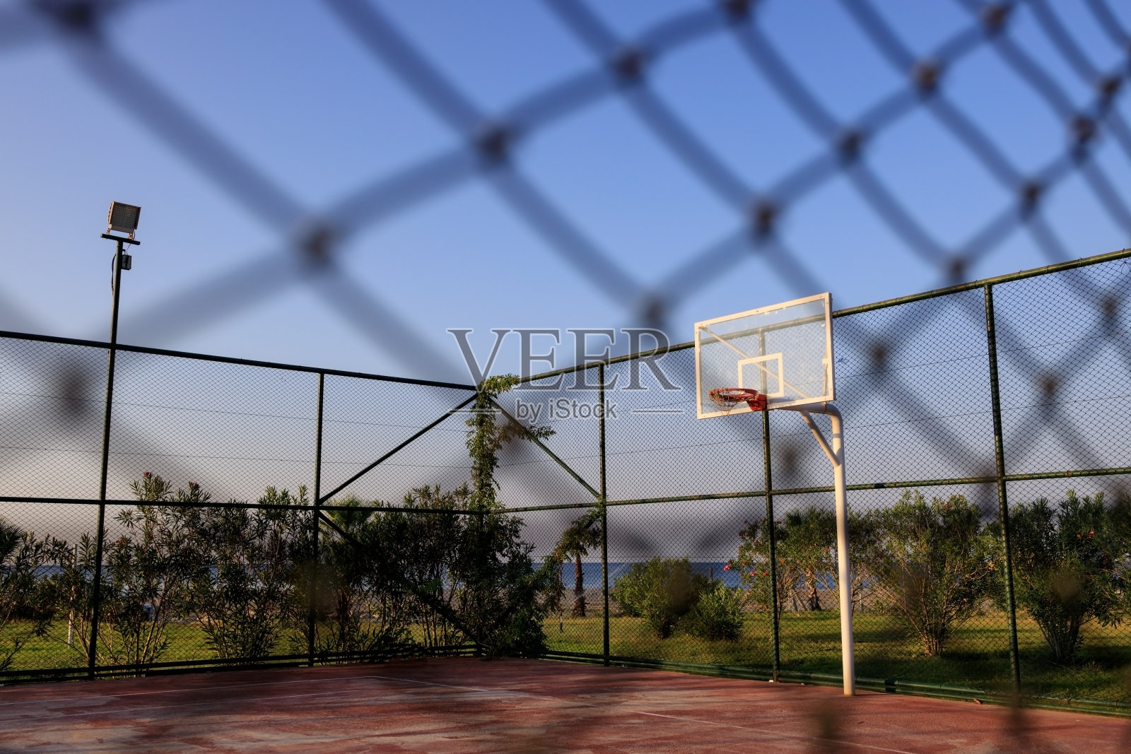 在晴朗的一天,透过网眼观看土耳其阿兰亚的篮球场照片摄影图片