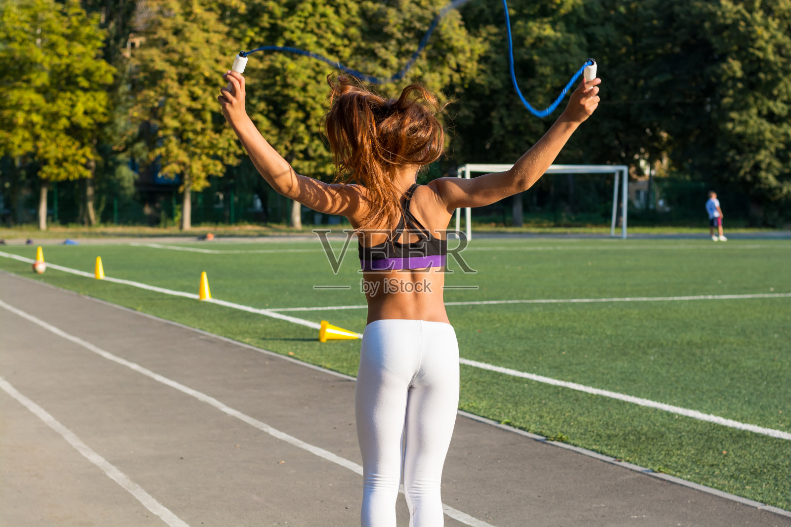 在学校体育场跳绳的少女照片摄影图片