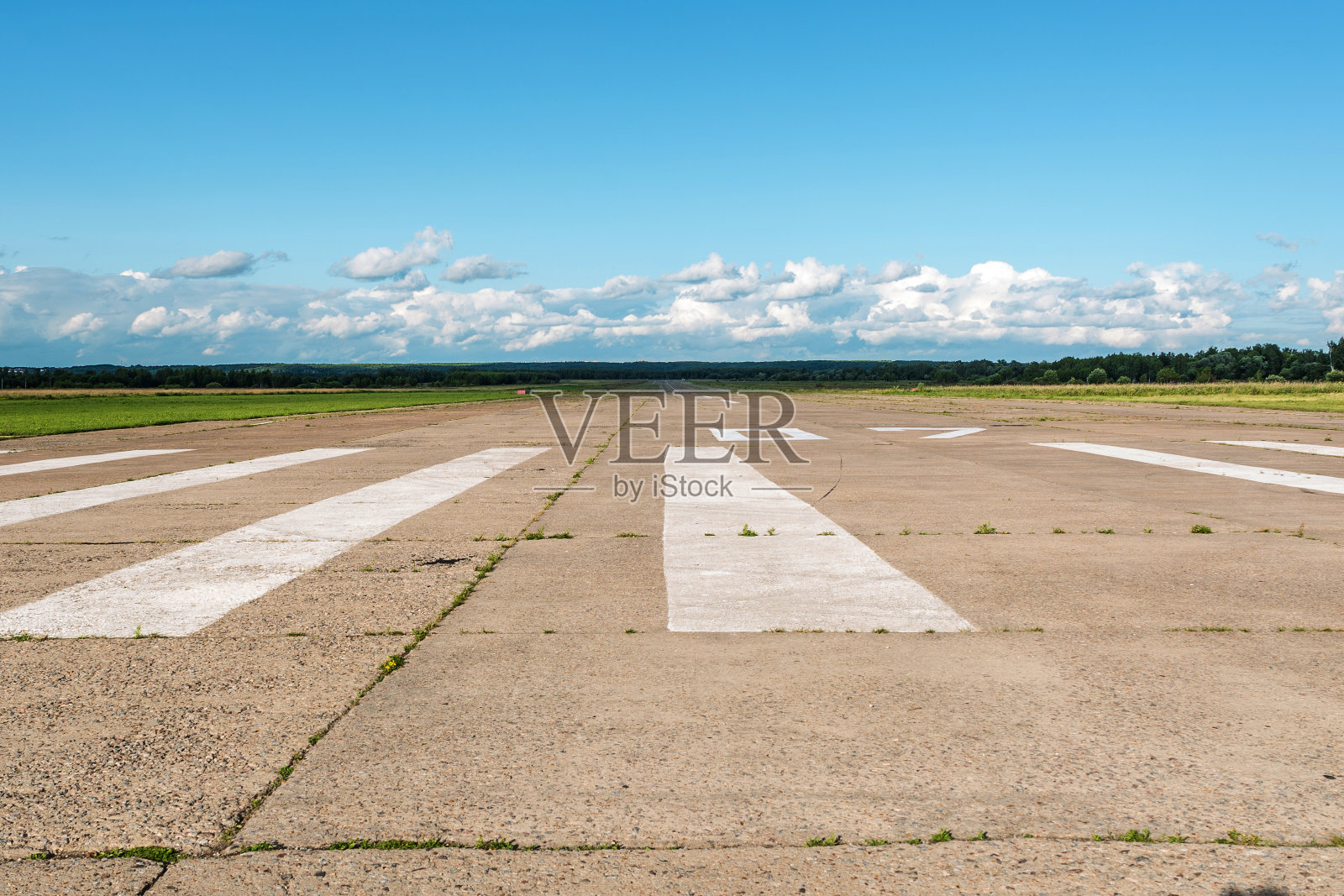 一个乡村小机场的跑道映衬着蓝天和白云的机场。孤独的机场。照片摄影图片
