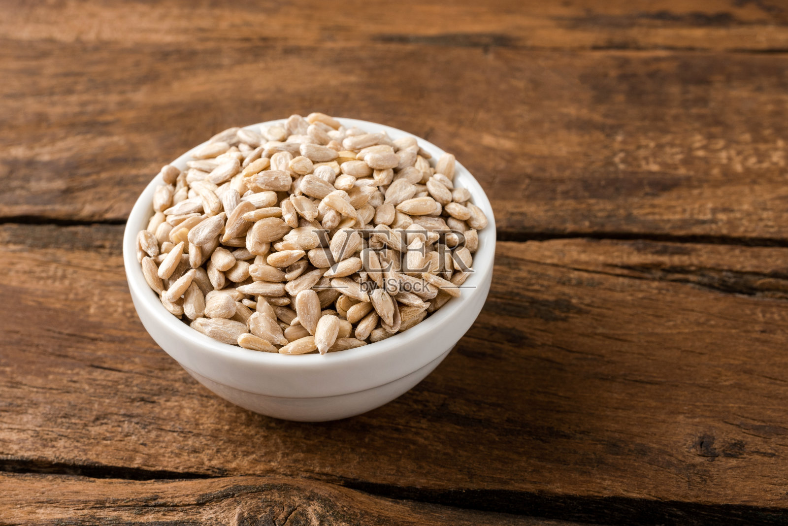 葵花籽在碗上复古的木制背景照片摄影图片