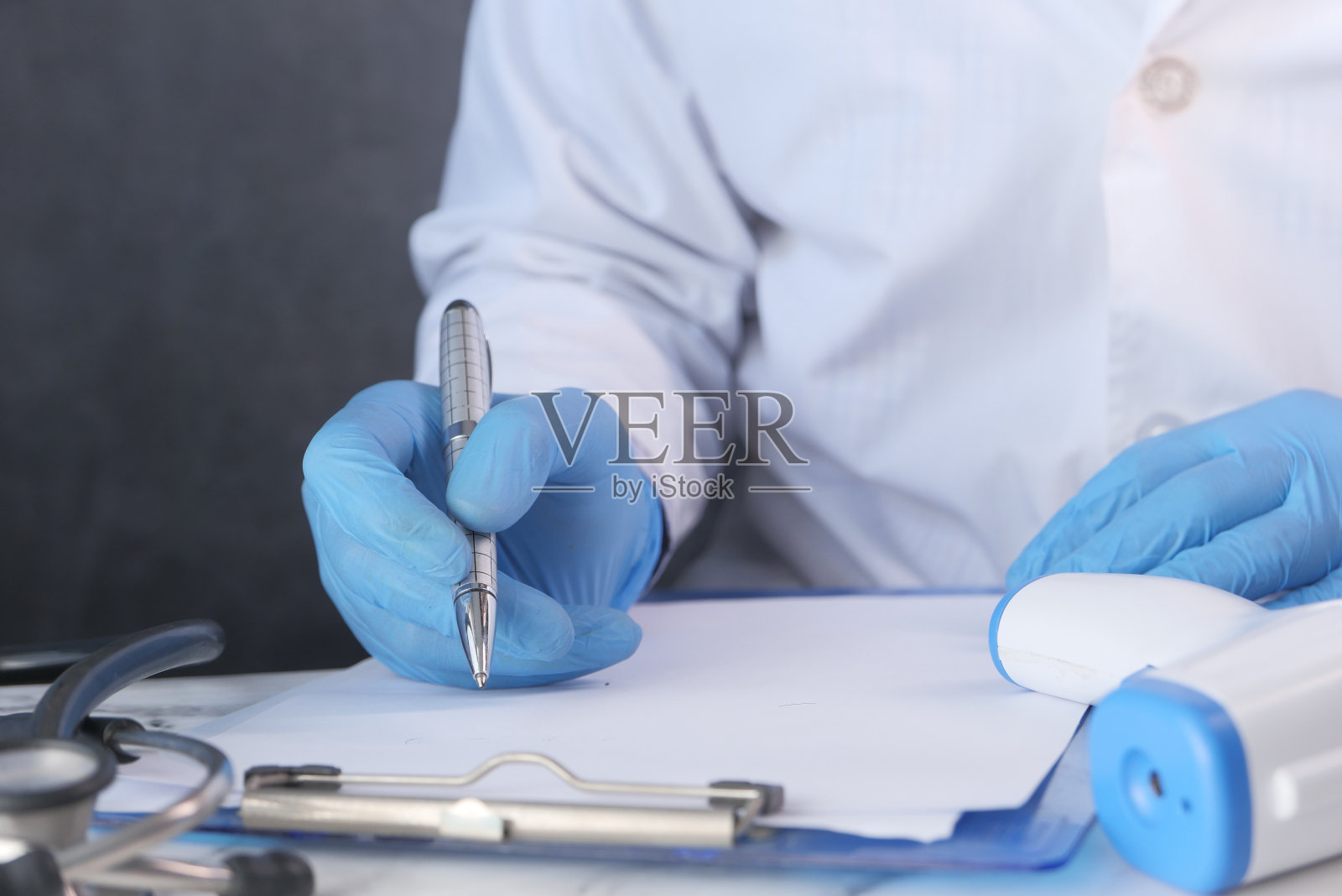 医生递上防护玻璃,在桌上写下处方,照片摄影图片