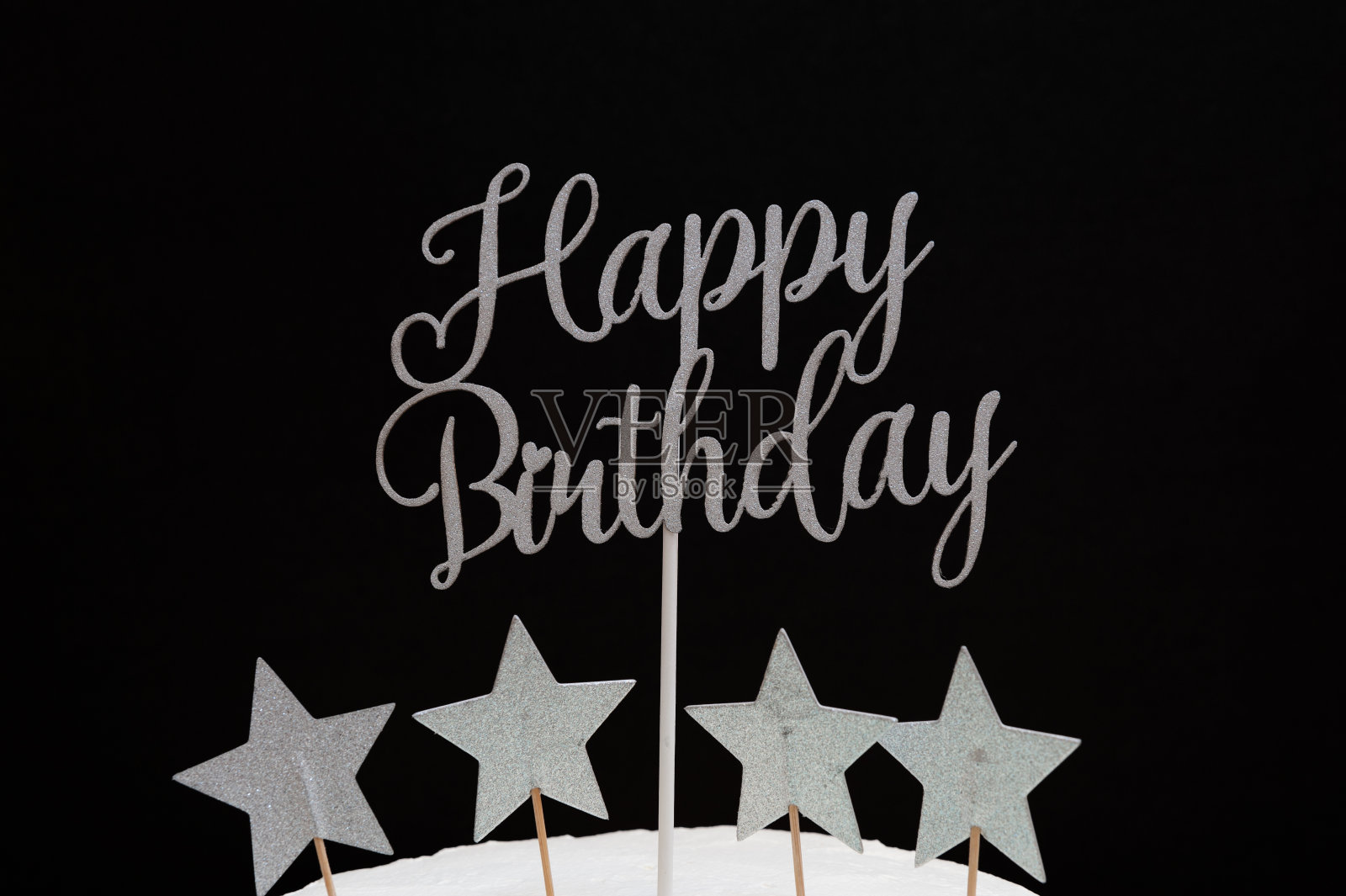 用星星形状的银色字母写的生日快乐。孤立在黑色背景上照片摄影图片