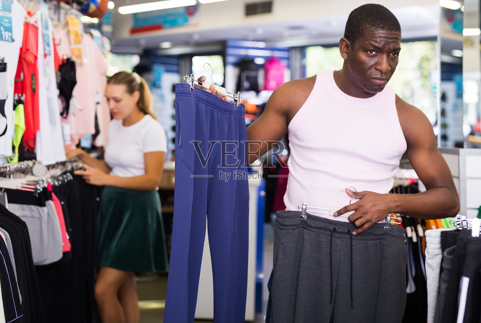 男性顾客选择运动裤照片摄影图片