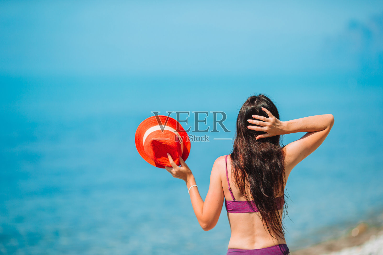 年轻漂亮的女人在热带海岸玩。照片摄影图片