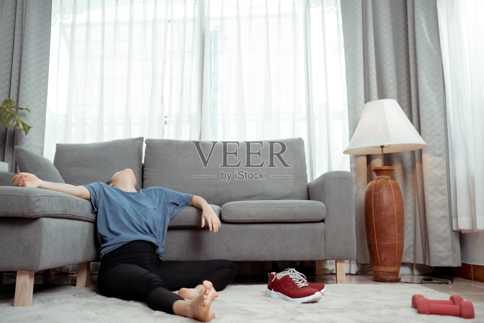 运动年轻的亚洲女人疲惫地做运动之间的地板在客厅,运动训练在线健身班,家庭锻炼健康的生活方式。照片摄影图片