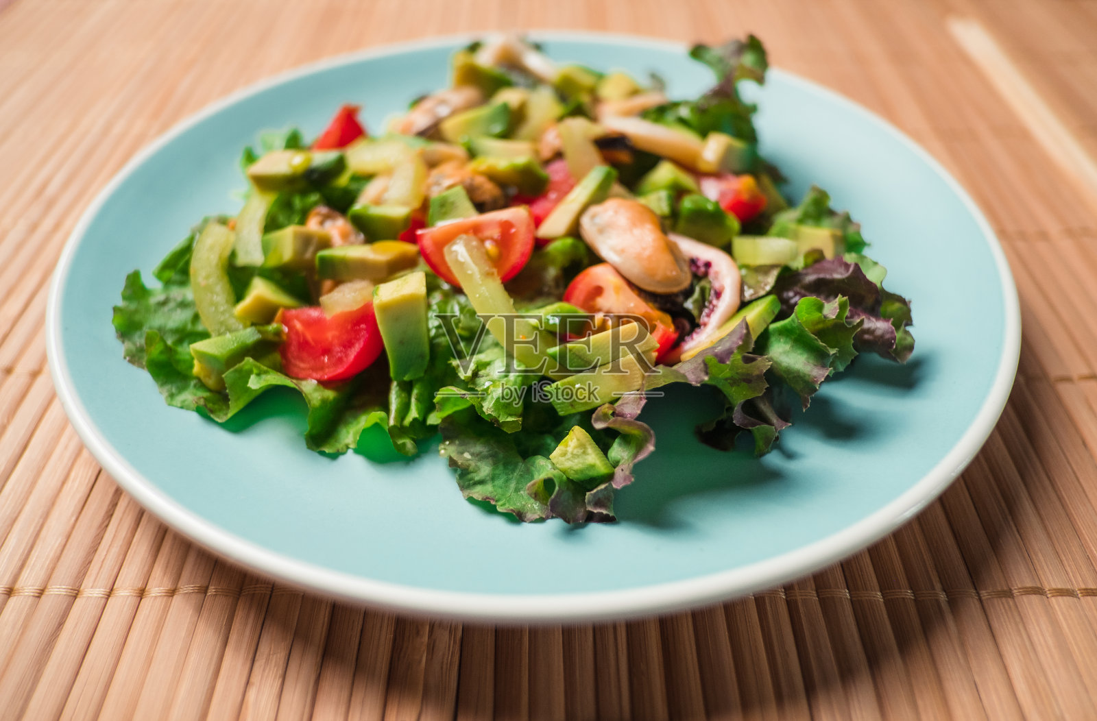 色拉配海鲜放在彩色盘子里照片摄影图片