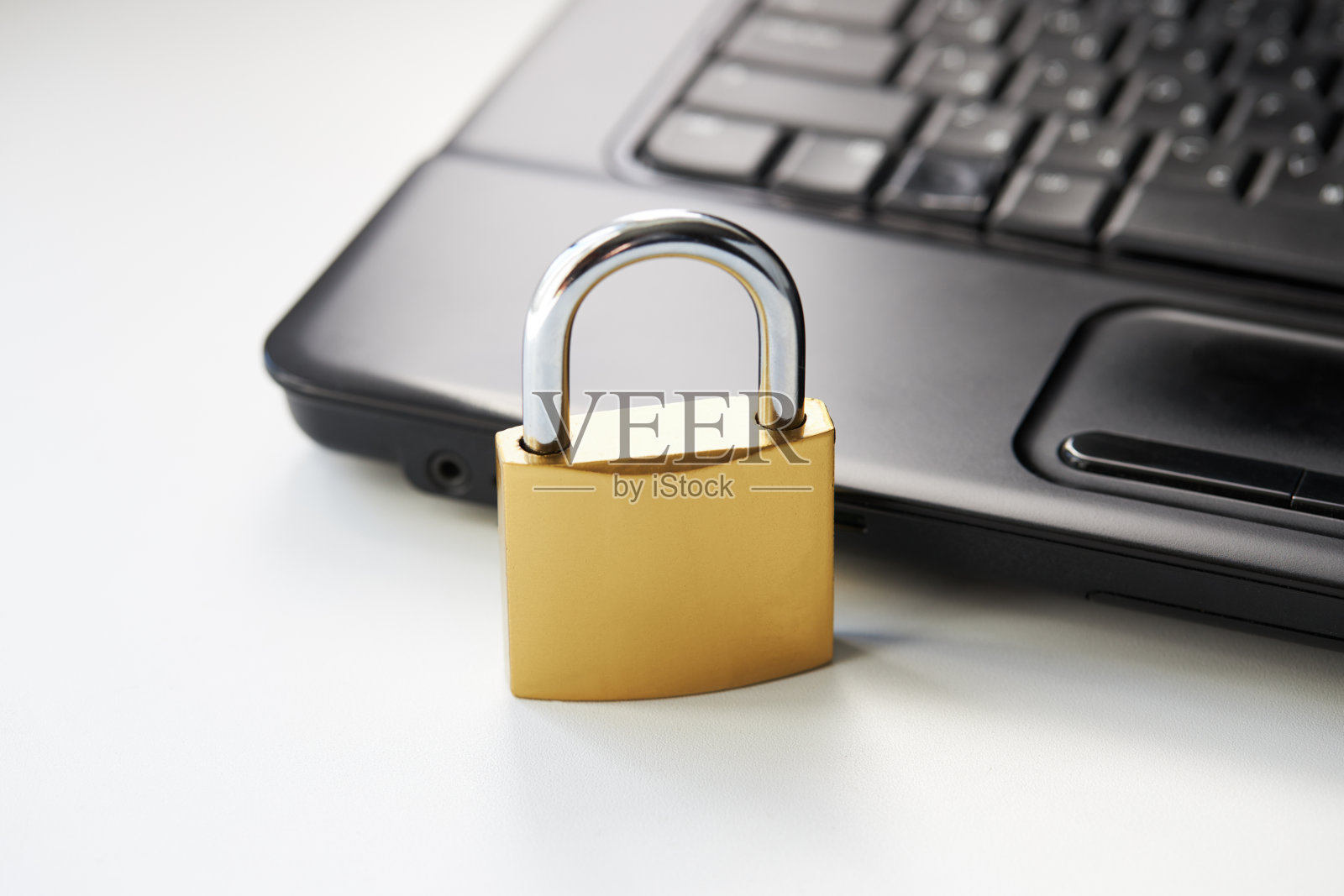 白色背景的黑色笔记本电脑键盘上的金色挂锁。网络安全的概念。杀毒软件的概念。电子钱包象征照片摄影图片