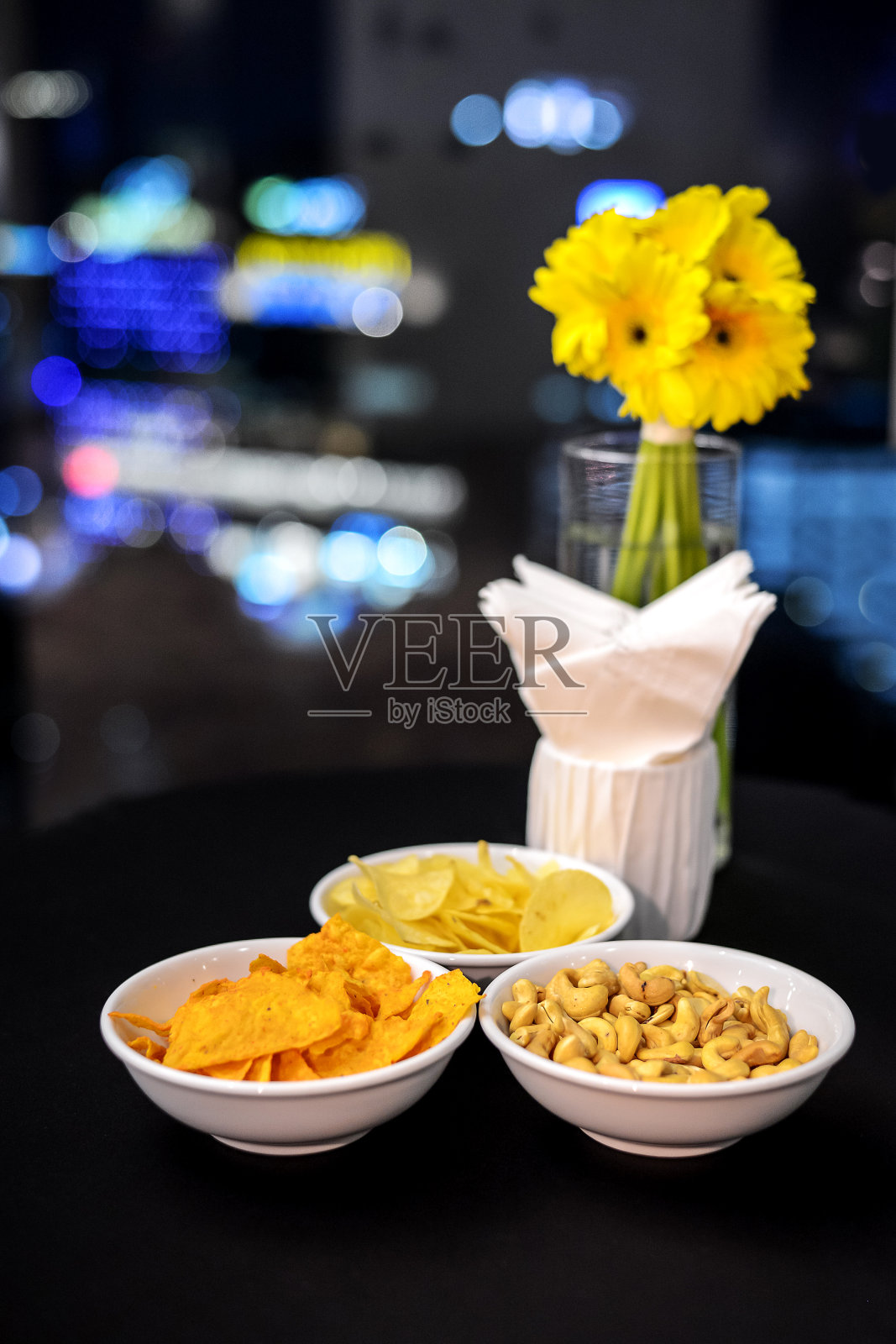 美味的派对小吃选择在一个白色的瓷盘在晚上,nachow,土豆片,和花生。照片摄影图片