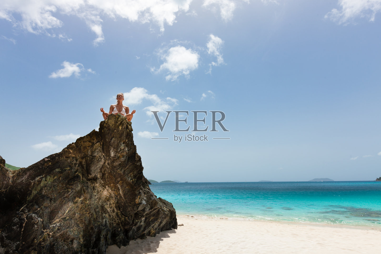 在热带海滩上做瑜伽冥想的女人照片摄影图片