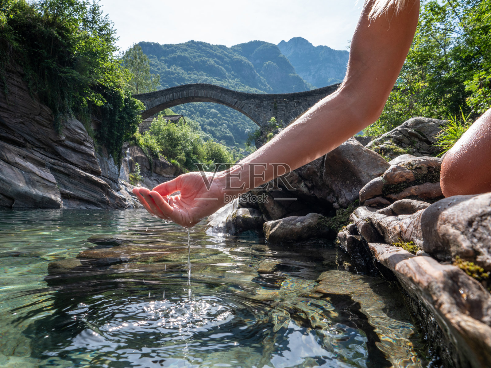 用手从河里舀水照片摄影图片