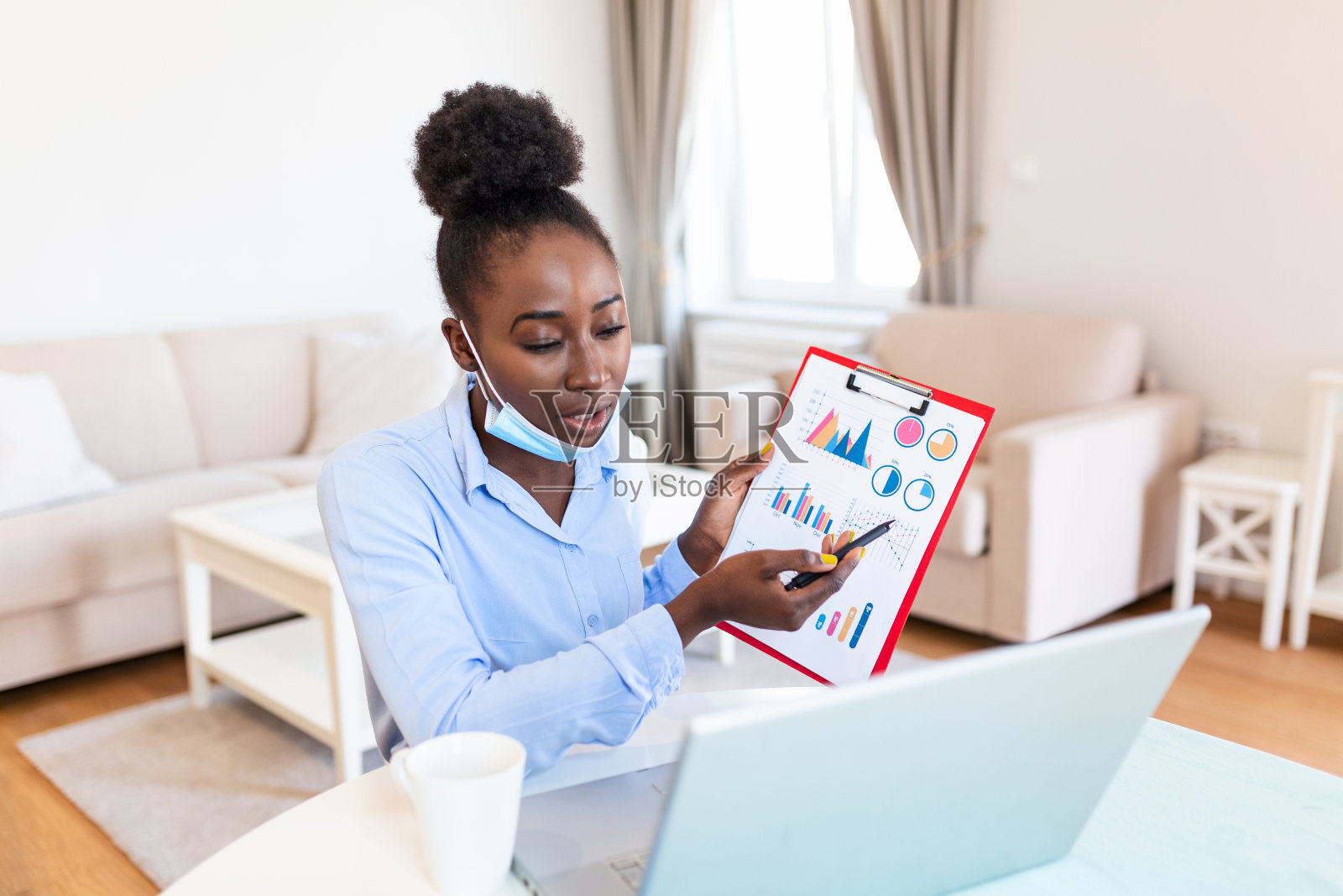 非裔美国女商人在新冠肺炎疫情期间被隔离期间进行视频会议。通过视频电话分析股票市场图表和关键业绩指标照片摄影图片