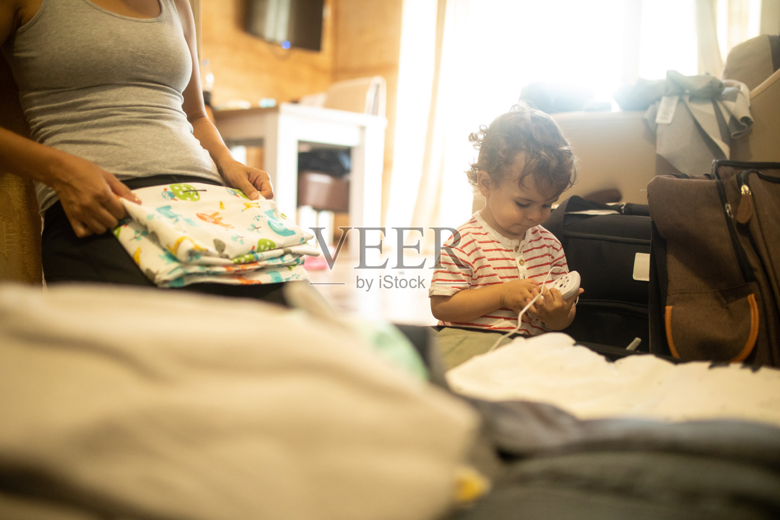 小男孩在帮妈妈收拾行李去度假照片摄影图片