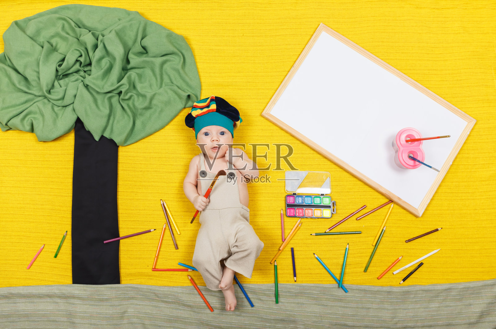 小男孩画艺术作品。英俊的孩子躺在黄色的背景上照片摄影图片