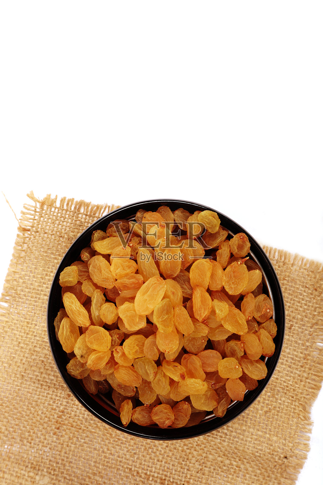 碗与干金黄色葡萄干孤立在白色。干葡萄。照片摄影图片