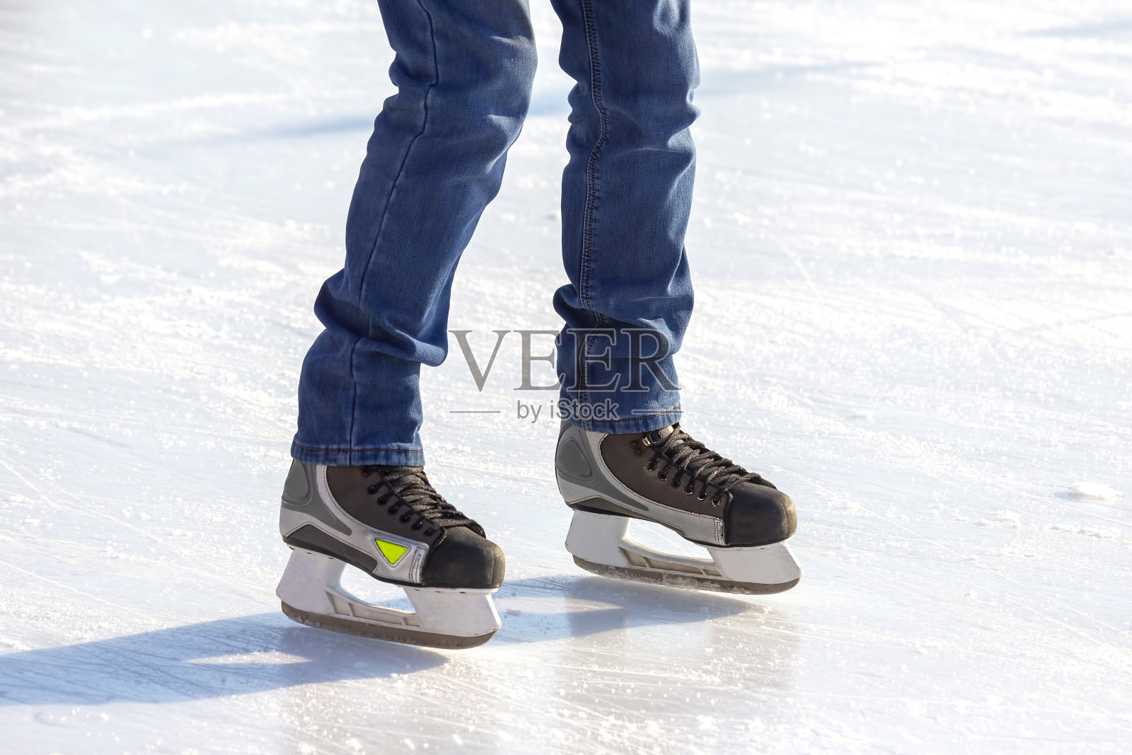 溜冰场上滑冰的人的腿。爱好和休闲。冬季运动照片摄影图片