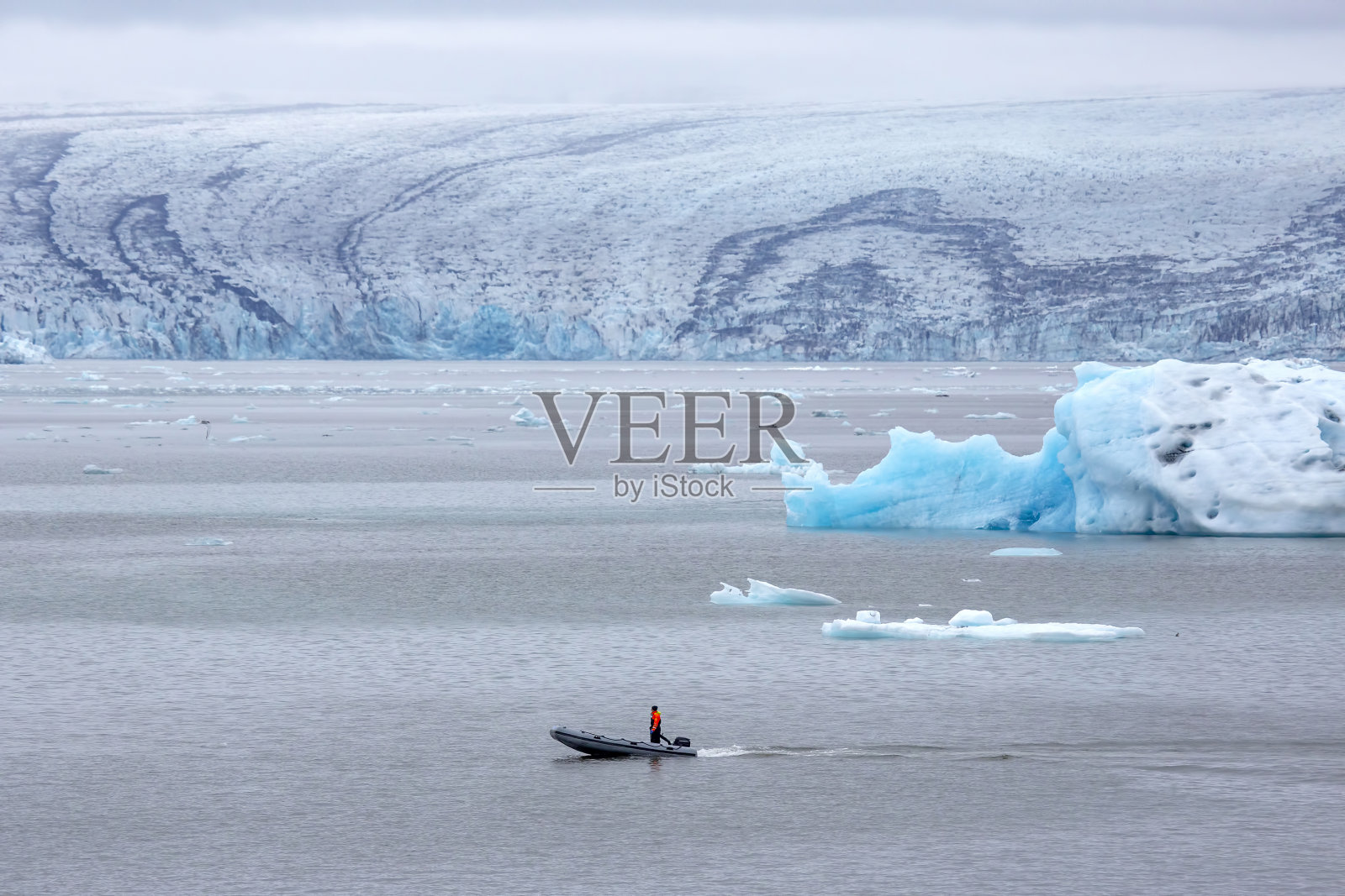 在冰岛的冰川泻湖上驾驶摩托艇的男人照片摄影图片
