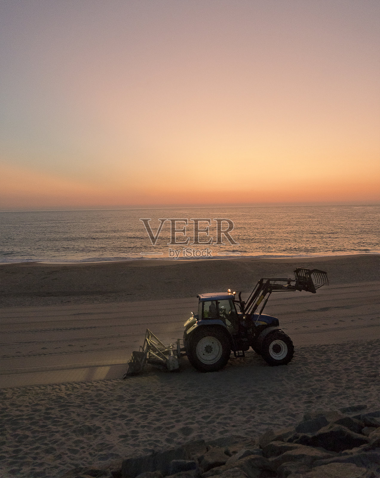 葡萄牙明德罗日落海滩上的拖拉机照片摄影图片