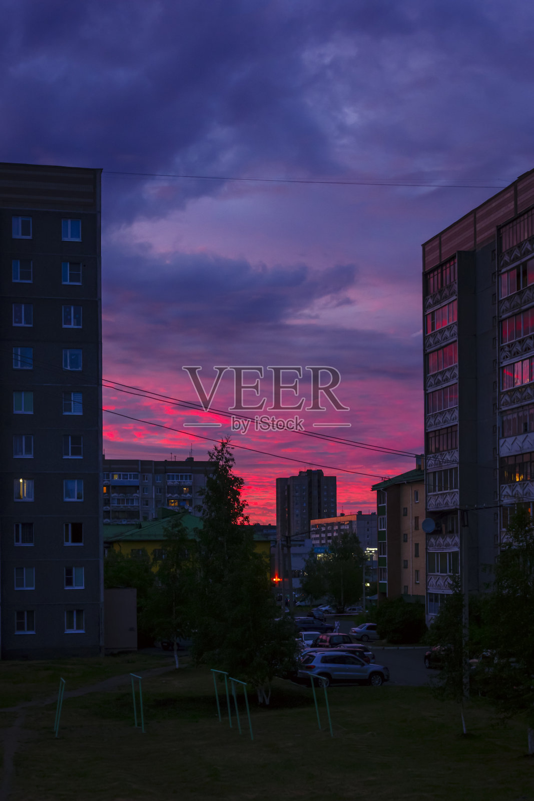 戏剧性的多云天空与深红色的日落在城市,垂直形式照片摄影图片