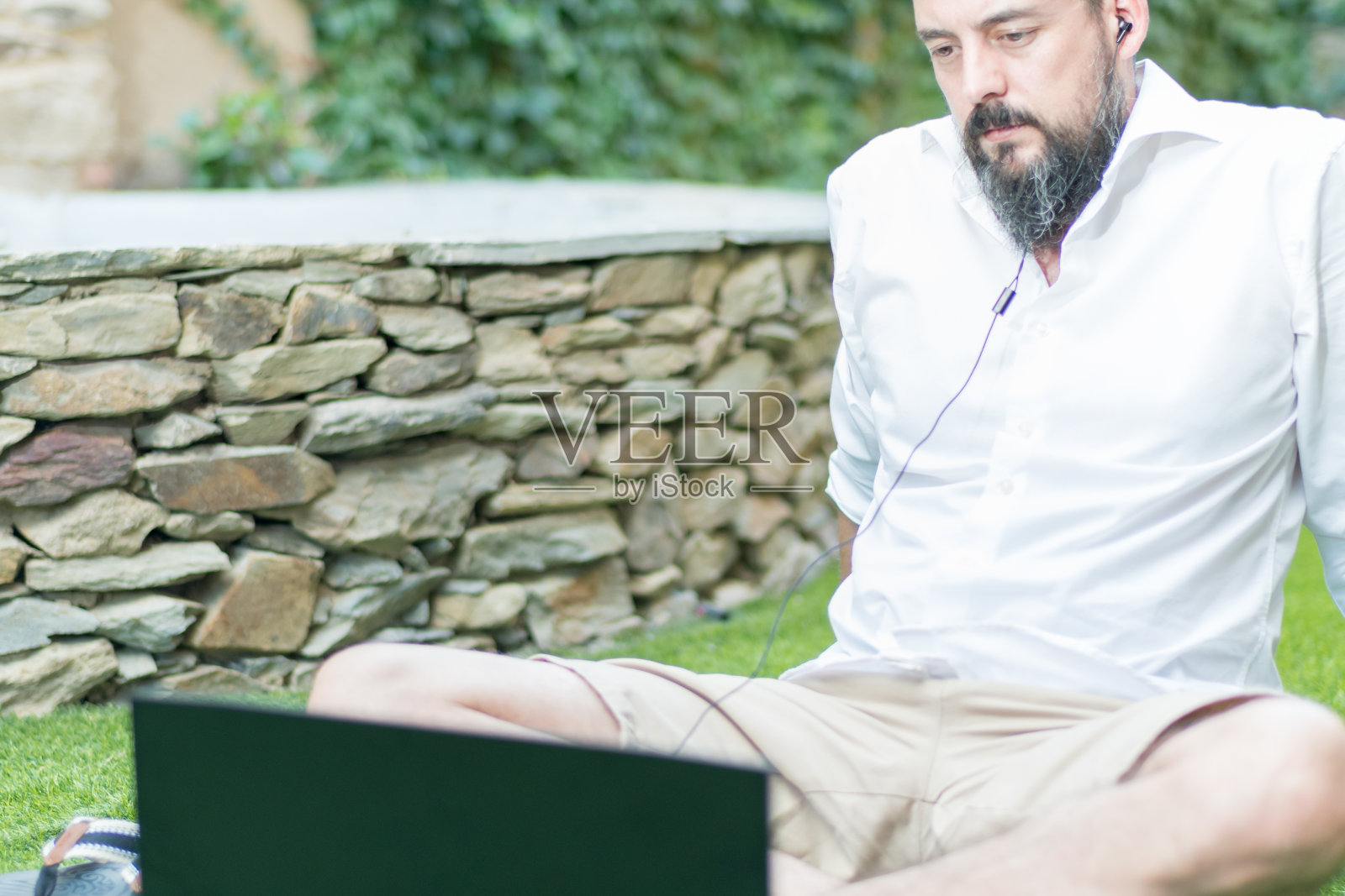 留着胡子戴着耳机开视频会议的嬉皮士照片摄影图片