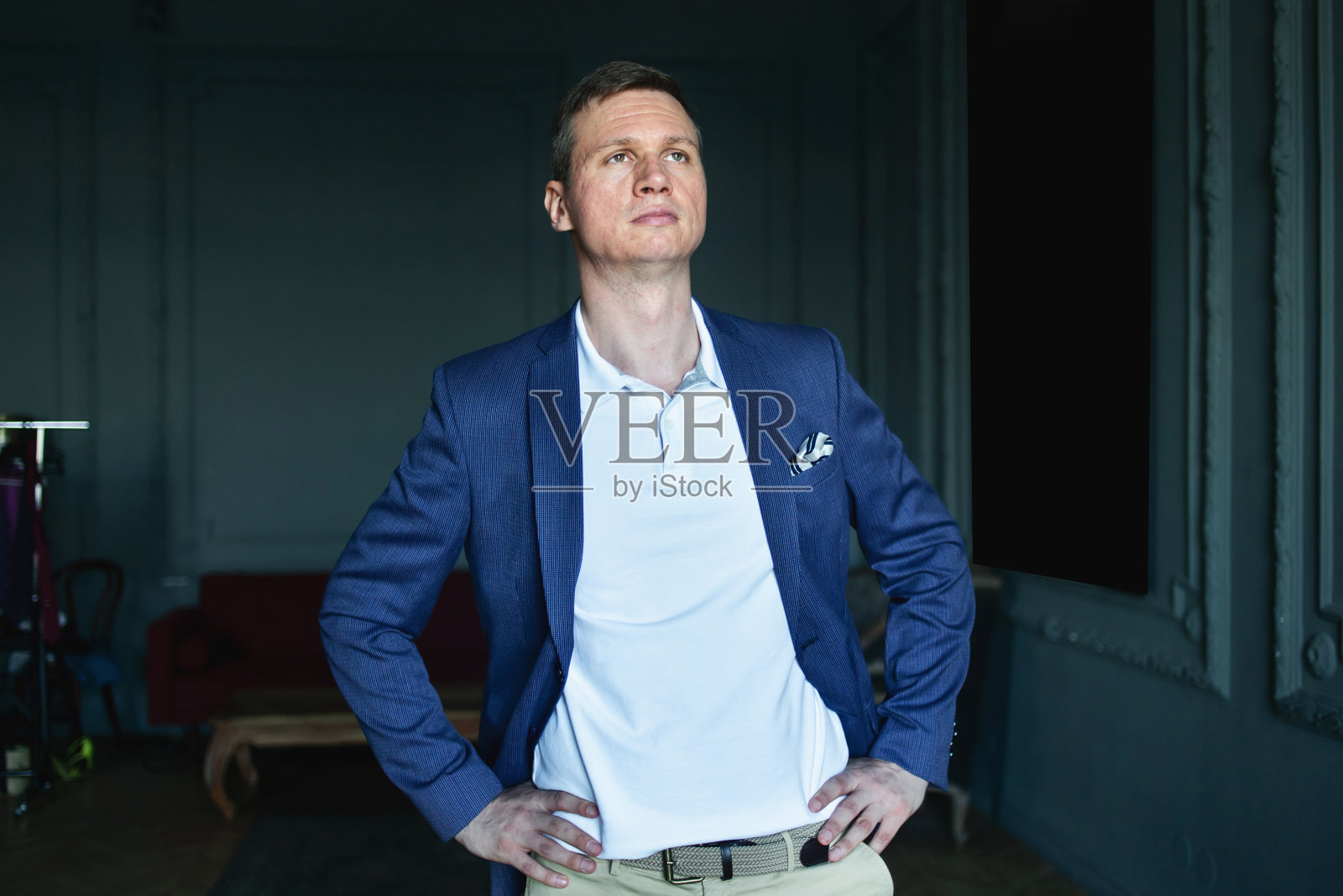 一个穿着夹克,英俊潇洒的男人在房间里照片摄影图片