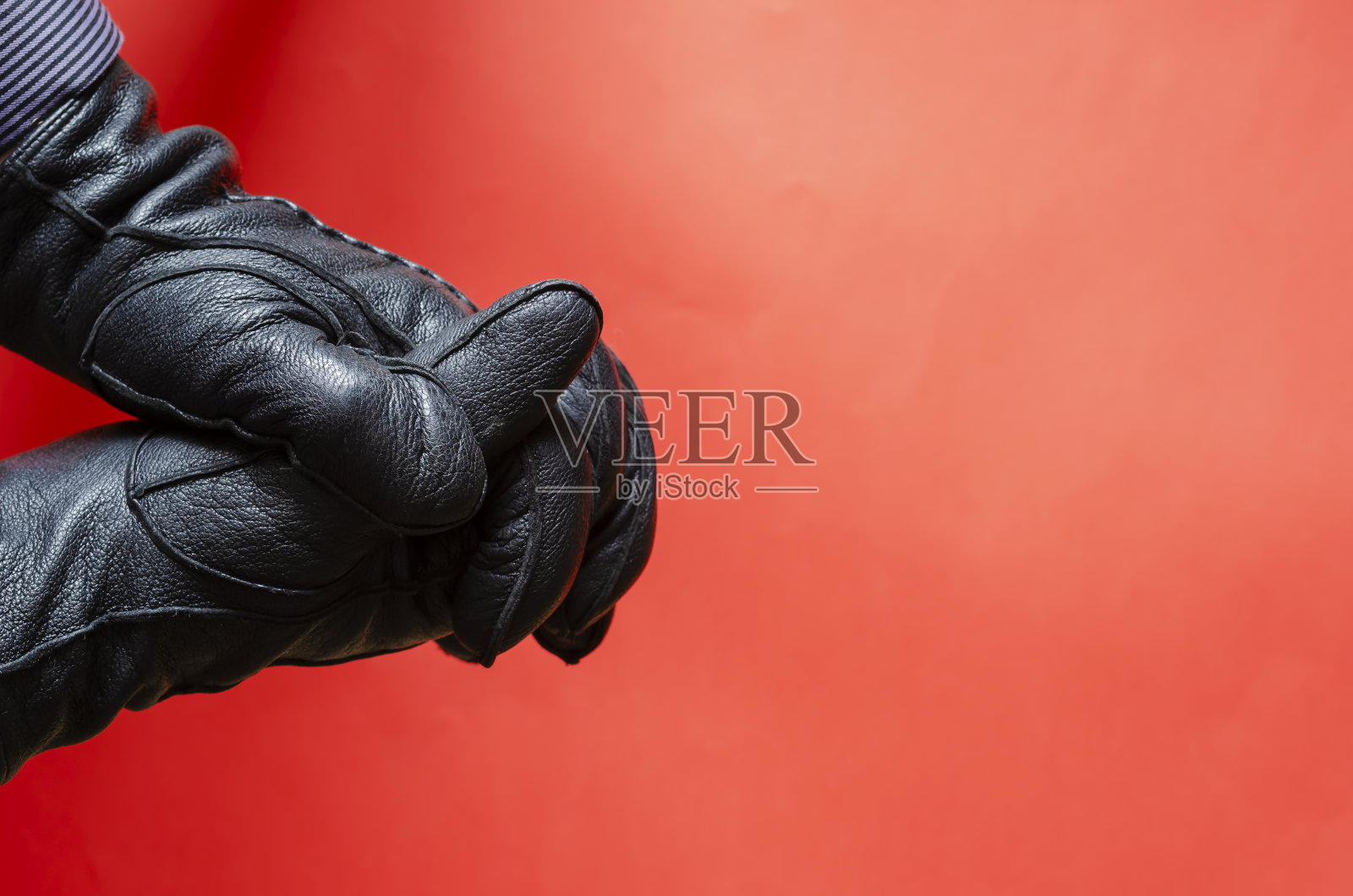 在珊瑚的背景下,男性手在皮手套手势。照片摄影图片