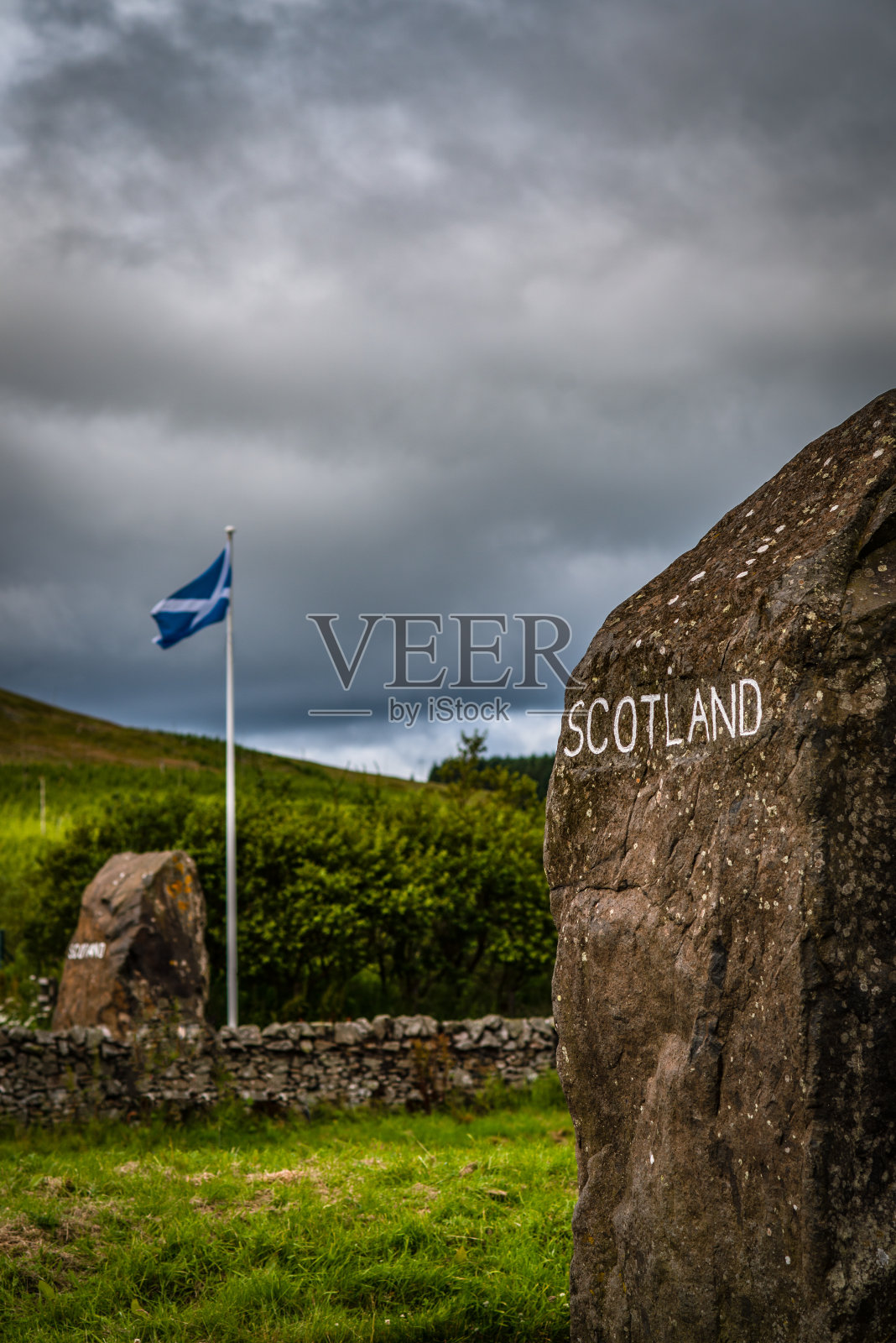 苏格兰国旗和雕刻的石头标志苏格兰和英格兰之间的边界_照片摄影图片