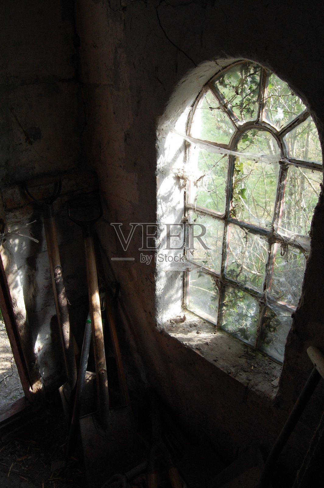 高角度视角的铁锹和其他工作工具和一个旧窗户。照片摄影图片