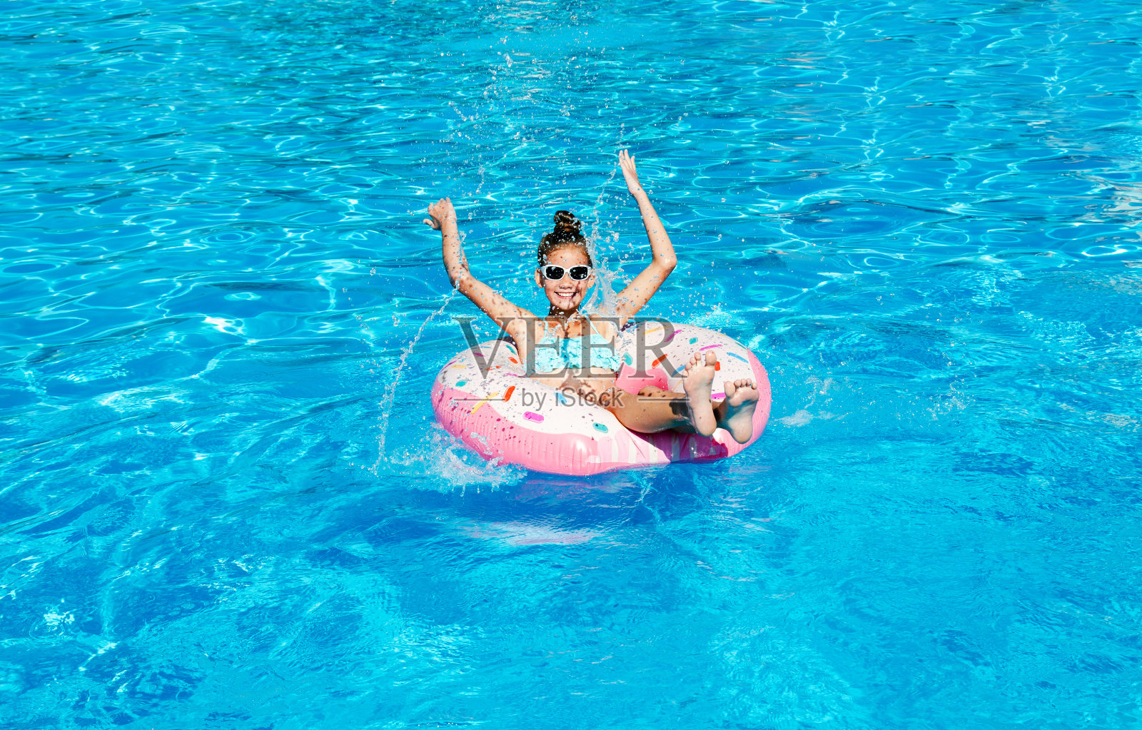 可爱的微笑小女孩在游泳池与橡胶圈照片摄影图片