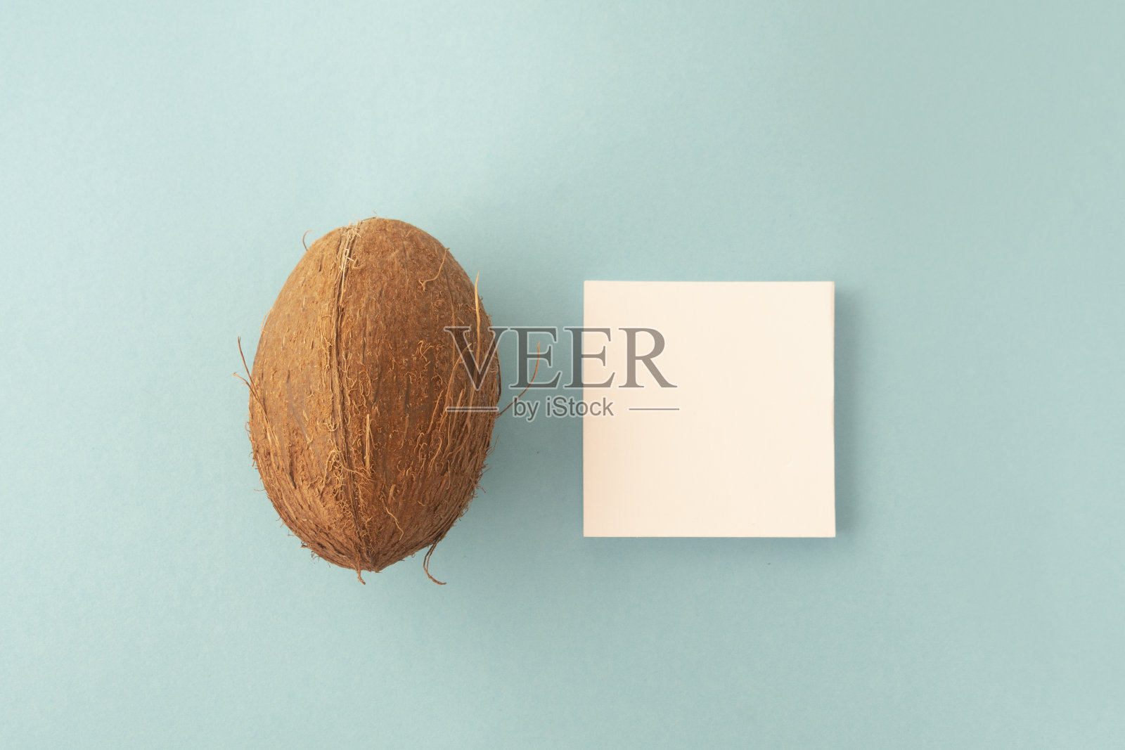 平躺着夏日的背景。白色空白和椰子在蓝色背景。夏季设计模板照片摄影图片