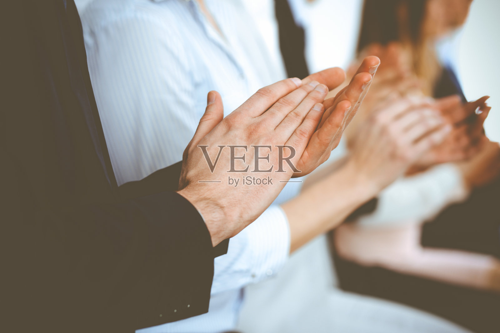 商务人士在会议或会议上拍手、鼓掌、举手。一群不知名的商人和妇女在现代白人办公室。成功的团队合作或企业培训理念照片摄影图片