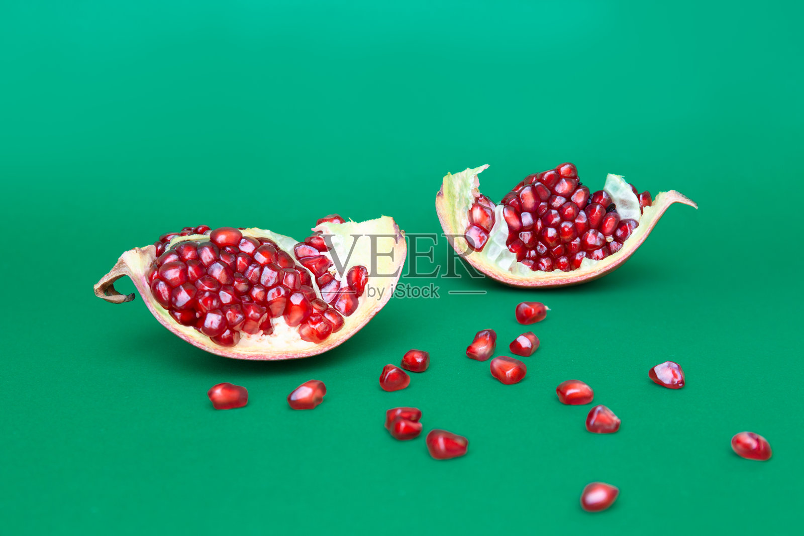 成熟的有机石榴果实孤立在绿色背景。照片摄影图片