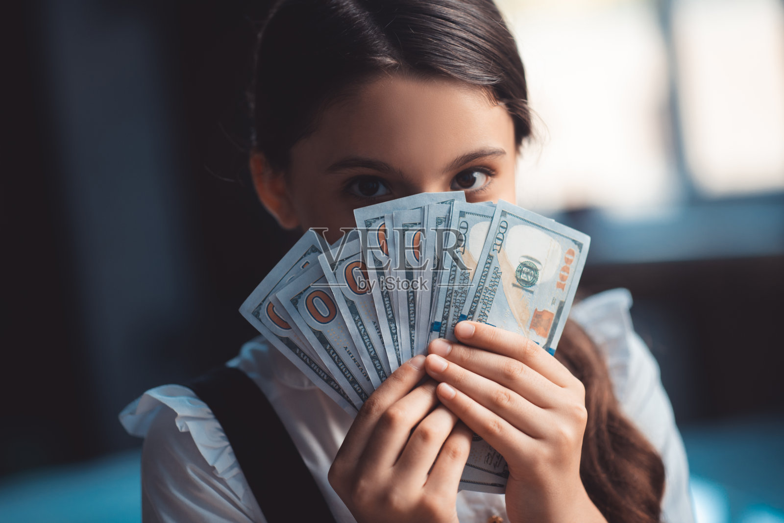 女孩拿着美元,闭着脸照片摄影图片