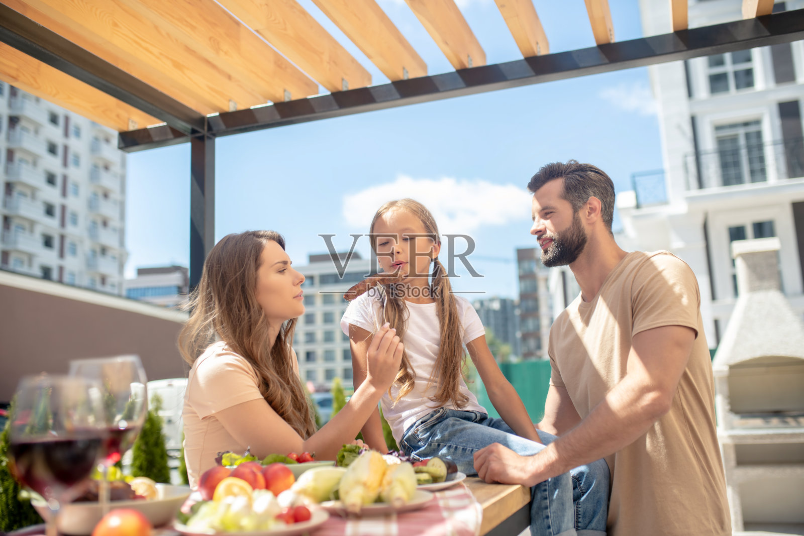 年轻的家庭在外面吃饭,看起来很高兴照片摄影图片