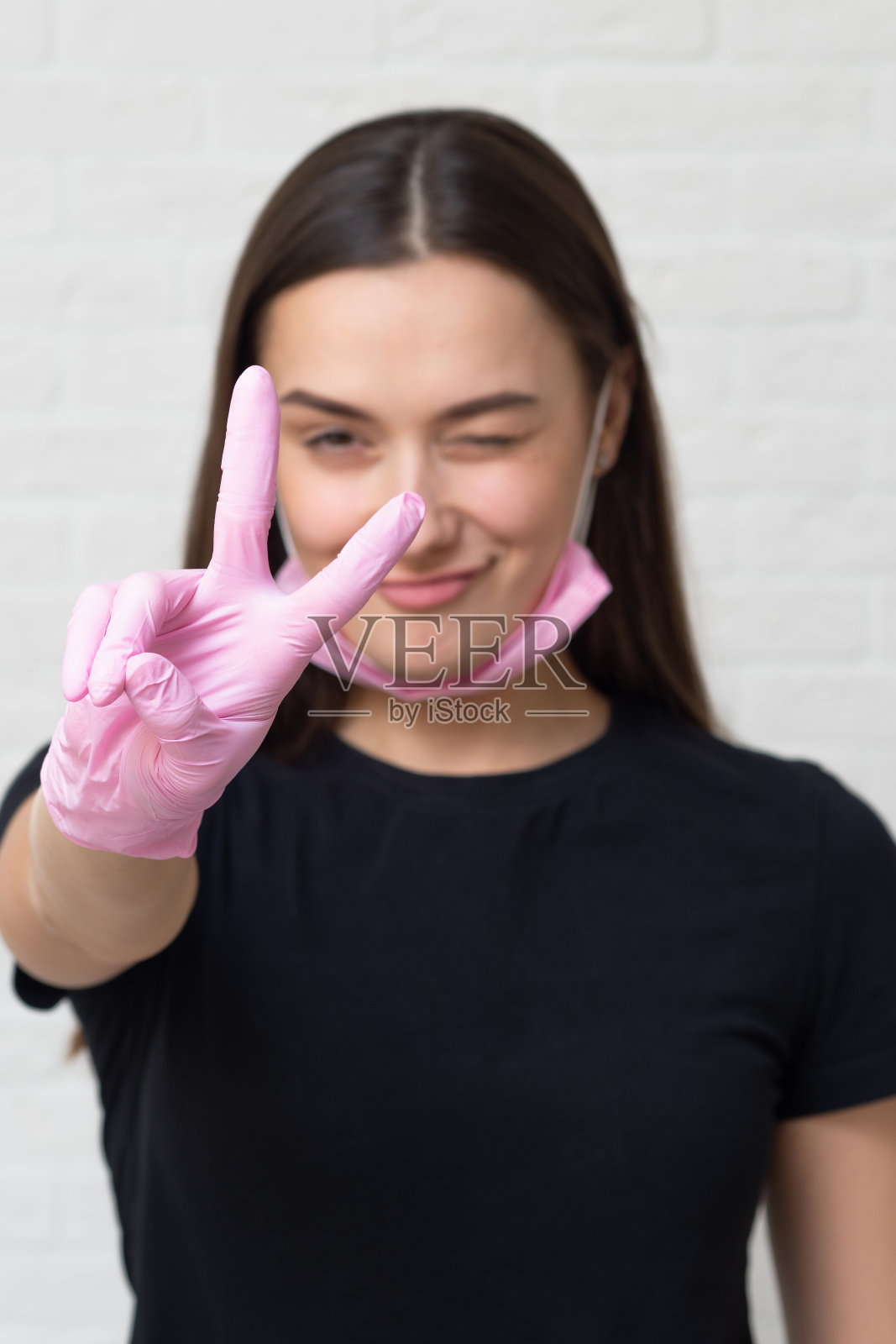 年轻的美容师和眉毛专家会戴上防护手套和面具和客户一起工作,照片摄影图片