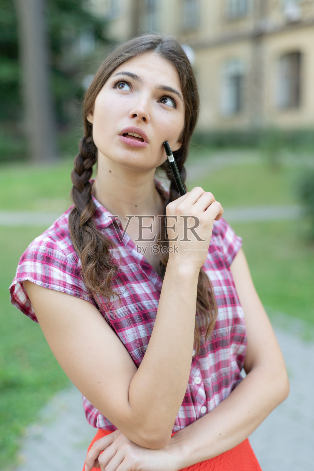 年轻的女学生拿着笔照片摄影图片